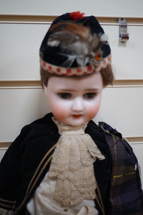 A Schoenau & Hoffmeister bisque doll, mould 1909, with sleeping eyes and open mouth, jointed wood and composition body, in a tartan outfit, 60cm. Condition - good.